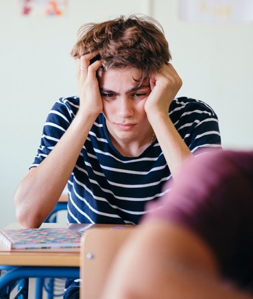 Adolescent seul en classe, victime de harcèlement scolaire